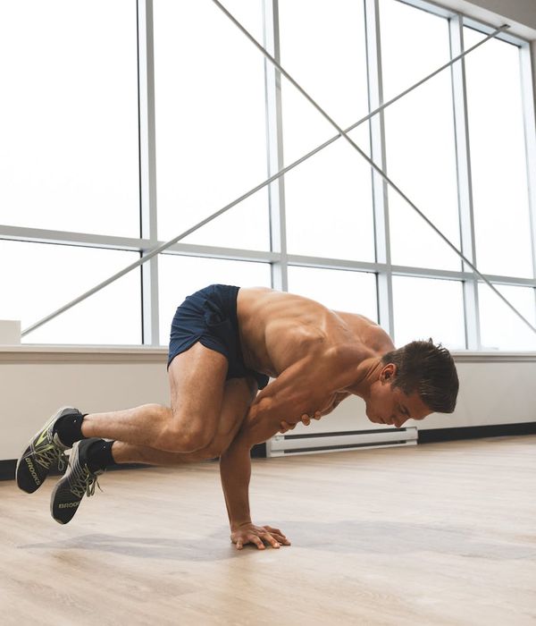 Man performing a controlled strength exercise in a modern gym.